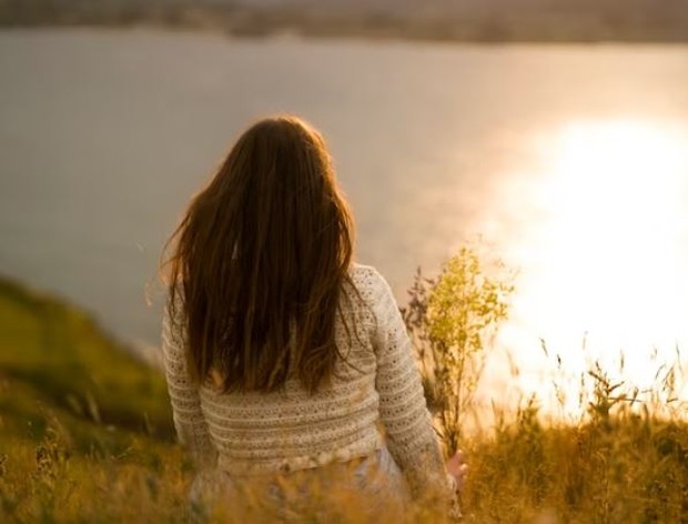 Perempuan sedang duduk di alam terbuka