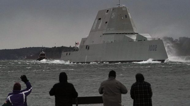 FILE — Spectators watch the USS Lyndon B. Johnson Zumwalt-class destroyer travel down the Kennebec River on its way to sea Jan. 12, 2022, in Phippsburg, Maine. The U.S. Navy, following costly lessons after cramming too much new technology onto warships and speeding them into production, is slowing down the design and purchase of its next-generation destroyer, and taking extra steps to ensure new technology like lasers and hypersonic missiles have matured before pressing ahead. (AP Photo/Robert F. Bukaty, File)
