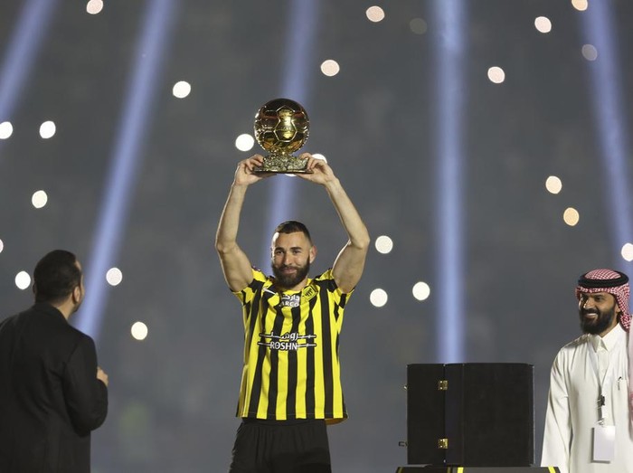 Saudi soccer team Al Ittihad player Karim Benzema holds the Ballon d'Or 2022 trophy during his presentation ceremony at King Abdullah Sports City Stadium in Jeddah, Saudi Arabia, Thursday, June 8, 2023. Benzema, who left Real Madrid after 14 years and 648 games, is set to play against his former Madrid teammate Cristiano Ronaldo, who joined Al-Nassr in January. (AP Photo)