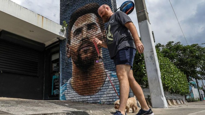 A man walks in front of a mural depicting Argentine football player Lionel Messi in Miami on June 7, 2023. Lionel Messi on Wednesday announced he will sign for Major League Soccer side Inter Miami, choosing the United States as his next destination over a Barcelona reunion or blockbuster deal to play in Saudi Arabia. (Photo by Giorgio Viera / AFP) (Photo by GIORGIO VIERA/AFP via Getty Images)