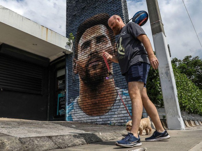 A man walks in front of a mural depicting Argentine football player Lionel Messi in Miami on June 7, 2023. Lionel Messi on Wednesday announced he will sign for Major League Soccer side Inter Miami, choosing the United States as his next destination over a Barcelona reunion or blockbuster deal to play in Saudi Arabia. (Photo by Giorgio Viera / AFP) (Photo by GIORGIO VIERA/AFP via Getty Images)
