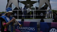 Orang-orang berfoto di samping replika trofi Liga Champions di Istanbul, Turki, Kamis (8/6/2023).