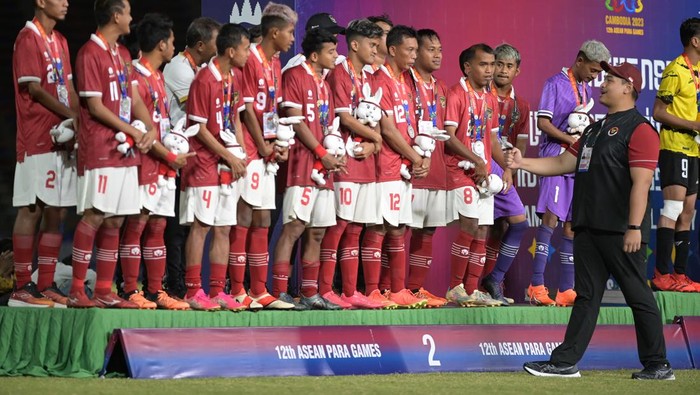 Menpora Dito Ariotedjo (kanan) menyapa para pesepak bola Indonesia saat Upacara Penghormatan Pemenang (UPP) final sepak bola CP ASEAN Para Games 2023 di National Olympic Stadium, Phnom Penh, Kamboja, Kamis (8/6/2023). Indonesia meraih medali perak setelah kalah dari Malaysia melalui adu pinalti dengan skor 2-4. ANTARA FOTO/Zabur Karuru/foc.