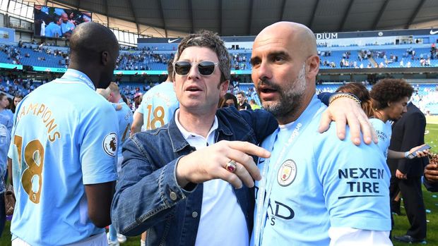 MANCHESTER, ENGLAND - MAY 06:  Noel Gallagher speaks to Josep Guardiola, Manager of Manchester City on the pitch after the Premier League match between Manchester City and Huddersfield Town at Etihad Stadium on May 6, 2018 in Manchester, England.  (Photo by Michael Regan/Getty Images)