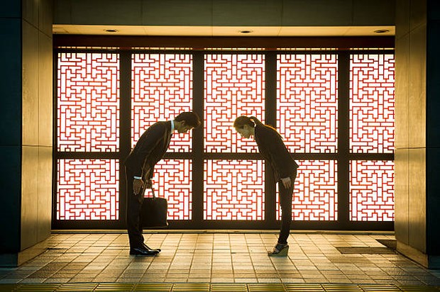 Salam antar rekan kerja atau kolega/ Foto dua orang melakukan salam membungkuk.