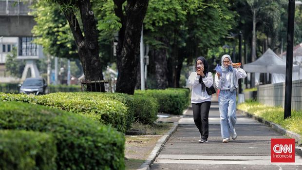 Pembukaan Kembali Trotoar Depan Kedubes AS Pejalan kaki melintasi trotoar di depan Kantor Kedutaan Besar Amerika Serikat di Jalan Medan Merdeka Selatan, Jakarta, Minggu, 11 Juni 2023. (CNN Indonesia/Adhi Wicaksono)