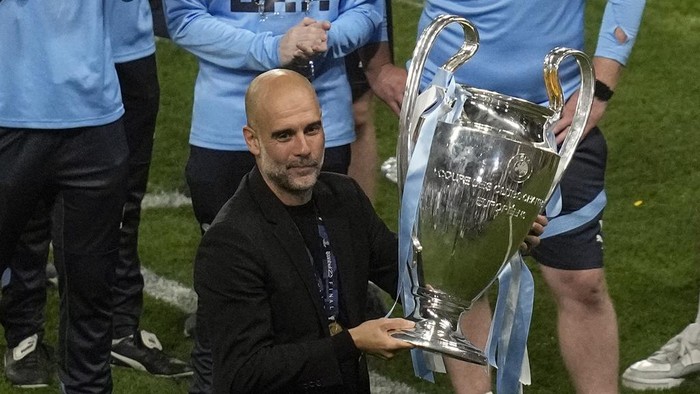 Manchester Citys head coach Pep Guardiola holds the trophy after winning the Champions League final soccer match between Manchester City and Inter Milan at the Ataturk Olympic Stadium in Istanbul, Turkey, Sunday, June 11, 2023. (AP Photo/Thanassis Stavrakis)