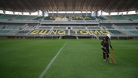 Pekerja menyapu rumput kering di Stadion Gelora Bung Tomo, Surabaya, Jawa Timur, Minggu (11/6/2023).   