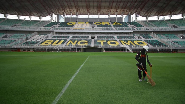 Pekerja menyapu rumput kering di Stadion Gelora Bung Tomo, Surabaya, Jawa Timur, Minggu (11/6/2023). Perawatan rutin tersebut dilakukan untuk persiapan lapangan jelang pertandingan FIFA Matchday antara Timnas Indonesia melawan Timnas Palestina pada Rabu (14/6/2023). ANTARA FOTO/Moch Asim/nz