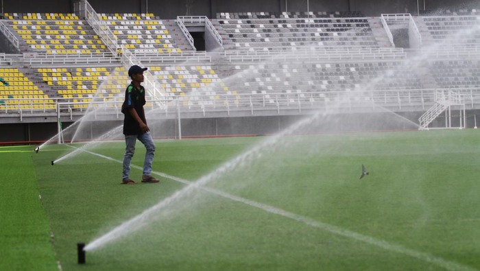 Pekerja menyapu rumput kering di Stadion Gelora Bung Tomo, Surabaya, Jawa Timur, Minggu (11/6/2023). Perawatan rutin tersebut dilakukan untuk persiapan lapangan jelang pertandingan FIFA Matchday antara Timnas Indonesia melawan Timnas Palestina pada Rabu (14/6/2023). ANTARA FOTO/Moch Asim/nz