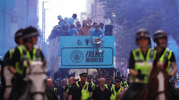 Soccer Football - Manchester City Victory Parade - Manchester, Britain - June 12, 2023 Manchester City's John Stones is pictured holding the Champions League trophy alongside Erling Braut Haaland and teammates as mounted police officers escort the parade through Manchester REUTERS/Phil Noble