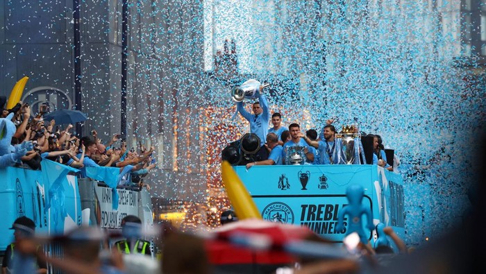 Soccer Football - Manchester City Victory Parade - Manchester, Britain - June 12, 2023
Manchester Citys Phil Foden celebrates with the Champions League trophy as Aymeric Laporte celebrates with the FA Cup trophy and Ruben Dias celebrates with the Premier League trophy during the parade REUTERS/Molly Darlington
