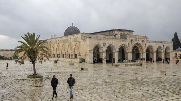 Palestinians walk in front of the Al-Aqsa mosque inside the almost deserted compound in the Old City of Jerusalem, after clerics took protective measures in a bid to stem the spread of the novel coronavirus, on March 20, 2020. Israel has 433 confirmed cases of COVID-19, with another 44 in the occupied Palestinian territories and tens of thousands in self-isolation. (Photo by AHMAD GHARABLI / AFP)