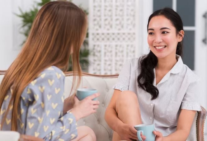 Dua perempuan sedang mengobrol