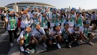 Orang-orang memakai topeng wajah pemain sepak bola Argentina Lionel Messi berpose di luar Workers Stadium sebelum pertandingan persahabatan antara Argentina dan Australia, di Beijing, China, Kamis (15/6/2023). (REUTERS/Tingshu Wang)  