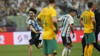 Aksi gocek si penyusup lapangan sungguh menyulitkan petugas keamanan. Foto: AP/Andy Wong