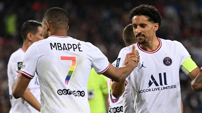 Paris Saint-Germains French forward Kylian Mbappe (L) is congatulated by his teamates Paris Saint-Germains Brazilian defender Marquinhos (R) after scoring a goal during the French L1 football match between Montpellier Herault SC and PSG at La Mosson stadium in Montpellier, southern France on May 14, 2022. (Photo by Pascal GUYOT / AFP)
