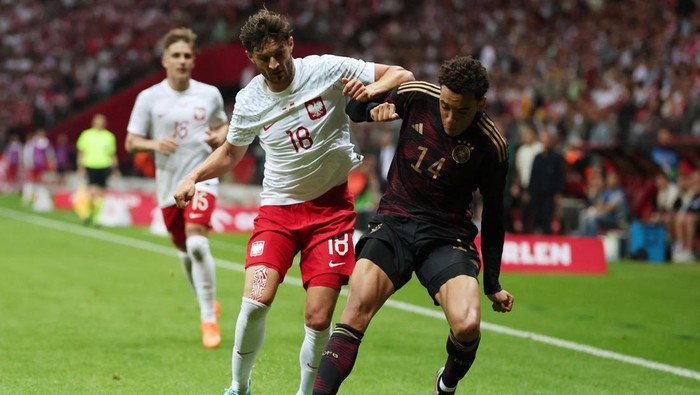 Soccer Football - International Friendly - Poland v Germany - Stadion Narodowy, Warsaw, Poland - June 16, 2023  Germanys Jamal Musiala in action with Polands Bartosz Bereszynski REUTERS/Kacper Pempel