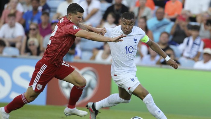 Frances Kylian Mbappe vies for the ball with Gibraltars Jayce Olivero, left, during the Euro 2024 group B qualifying soccer match between Gibraltar and France, at the Algarve Stadium outside Faro, Portugal, Friday, June 16, 2023. (AP Photo/Joao Matos)