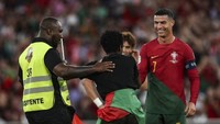 Sang penggemar kemudian memeluk Ronaldo sebelum bersimpuh di kaki kapten Portugal itu. (Foto: AFP/CARLOS COSTA)