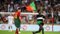 Satu orang penonton berlari memasuki lapangan pertandingan saat Portugal menjamu Bosnia di Estadio da Luz, Minggu 18 Juni 2023. (Foto: AFP/PATRICIA DE MELO MOREIRA)