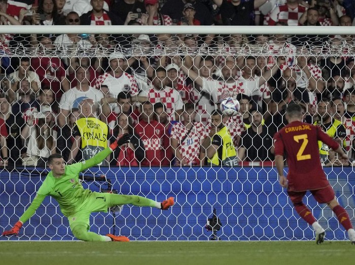 Spain's Dani Carvajal scores the winning penalty past Croatia goalkeeper Dominik Livakovic during a penalty shootout at the end of the Nations League final soccer match between Croatia and Spain at De Kuip stadium in Rotterdam, Netherlands, Sunday, June 18, 2023. Spain won 5-4 in a penalty shootout after the match ended tied 0-0. (AP Photo/Peter Dejong)