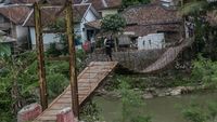 Potret Warga Nekat Lintasi Jembatan Gantung yang Rusak Parah di Lebak