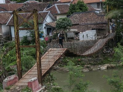 Potret Warga Nekat Lintasi Jembatan Gantung yang Rusak Parah di Lebak
