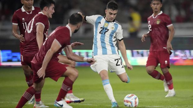 Argentina's Facundo Buonanotte, center, battles for the ball against Indonesia's Dendy Sulistiawan, from left to right, Elkan Baggott, and Jordi Amat during their friendly soccer match at Gelora Bung Karno Main Stadium in Jakarta, Indonesia, Monday, June 19, 2023. (AP Photo/Achmad Ibrahim)