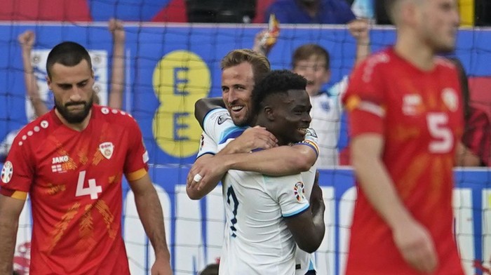 Englands Bukayo Saka, centre right, celebrates with Harry Kane after scoring his sides fourth goal during the Euro 2024 group C qualifying soccer match between England and North Macedonia at Old Trafford in Manchester, Monday June 19, 2023. (AP Photo/Dave Thompson)