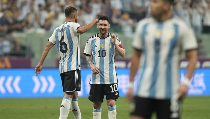 Argentinas Lionel Messi, center, and German Pezzela, left, reacts during during their friendly soccer match against Australia at the Workers Stadium in Beijing, China, Thursday, June 15, 2023. (AP Photo/Andy Wong)