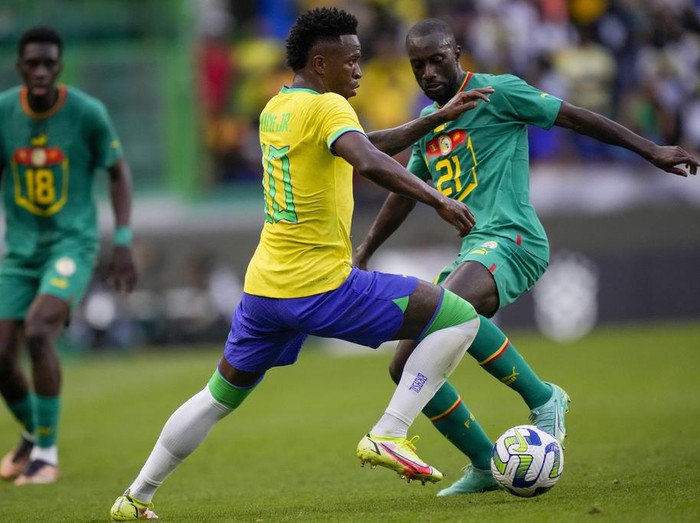Sadio Mane Brace, Senegal Taklukkan Brasil di FIFA Matchday Brazil's Vinicius Junior is challenged by Senegal's Youssouf Sabaly, right, during the international friendly soccer match between Brazil and Senegal, at the Alvalade Stadium in Lisbon, Portugal, Tuesday, June 20, 2023. (AP Photo/Armando Franca)