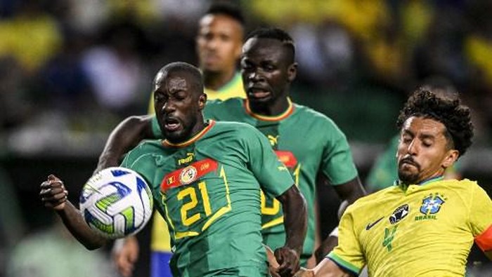 Brazils defender Marquinhos (R) vies with Senegals defender Youssouf Sabaly (L) during the international friendly football match between Brazil and Senegal at the Jose Alvalade stadium in Lisbon on June 20, 2023. (Photo by Patricia DE MELO MOREIRA / AFP)