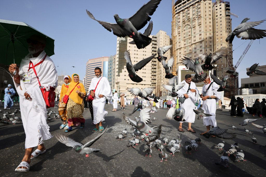 Men walk with umbrellas as people start arriving to perform the annual Haj in the Grand Mosque, in the holy city of Mecca, Saudi Arabia, June 24, 2023. REUTERS/Mohamed Abd El Ghany