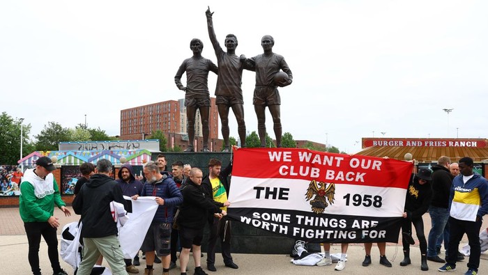 Soccer Football - Premier League - Manchester United Fans Protest - Old Trafford, Manchester, Britain - June 27, 2023 The United Trinity statue is pictured as Manchester United fans display a banner in protest against the Glazer family’s ownership of the club REUTERS/Molly Darlington