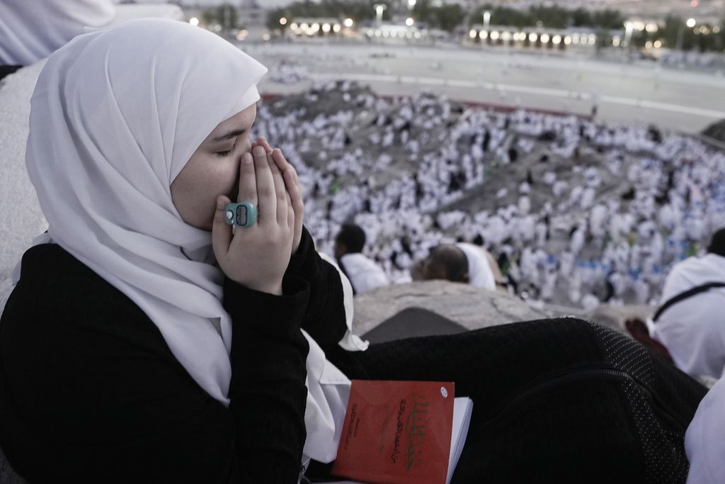 A Muslim pilgrim prays on the rocky hill known as the Mountain of Mercy, on the Plain of Arafat, during the annual Hajj pilgrimage, near the holy city of Mecca, Saudi Arabia, Tuesday, June 27, 2023. Around two million pilgrims are converging on Saudi Arabia's holy city of Mecca for the largest Hajj since the coronavirus pandemic severely curtailed access to one of Islam's five pillars. (AP Photo/Amr Nabil)