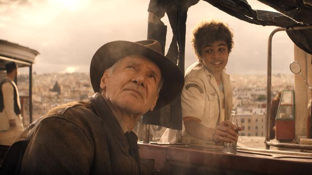 (L-R): Indiana Jones (Harrison Ford) and Teddy (Ethann Isidore) in Lucasfilm's INDIANA JONES AND THE DIAL OF DESTINY. ©2023 Lucasfilm Ltd. & TM. All Rights Reserved.