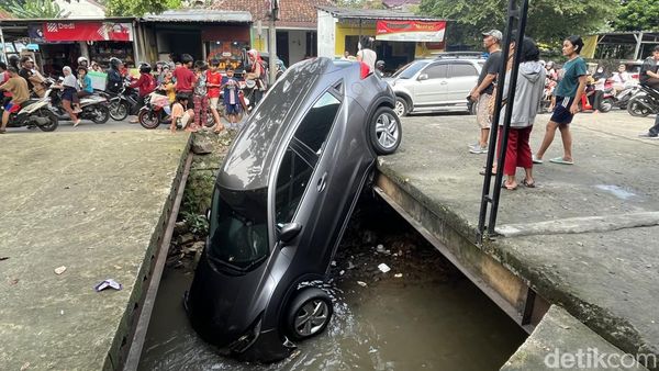 Mobil Nyungsep di Kali Depok Jadi Tontonan Warga