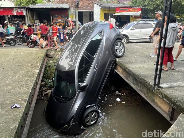 Mobil Nyungsep di Kali Depok Jadi Tontonan Warga