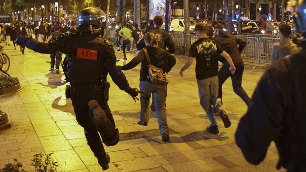 People run followed by police officers during riots following the death of Nahel, a 17-year-old teenager killed by a French police officer in Nanterre during a traffic stop, at Champs Elysees in Paris, France, July 1, 2023. REUTERS/Nacho Doce
