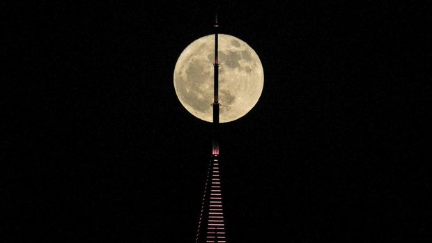 A super moon rises behind a tower in Dubai, United Arab Emirates, Monday, July 3, 2023. (AP Photo/Kamran Jebreili)