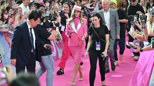Australian actress Margot Robbie (C) meets fans during a pink carpet event to promote her new film 