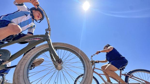 People cruise along the path north of the pier in Huntington Beach, Calif., Friday, June 30, 2023. (Jeff Gritchen/The Orange County Register via AP)