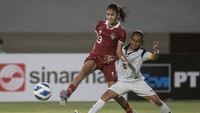 Pemain Timnas putri Indonesia U-19 Claudia Alexandra Scheunemann (kiri) berebut bola dengan Virginia Fatima Da Silva Branco (kanan).  