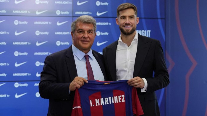 FC Barcelonas newly signed Spanish defender Inigo Martinez (R) poses for pictures holding his jersey with FC Barcelonas President Joan Laporta during his official presentation at the Joan Gamper training ground in Sant Joan Despi on July 13, 2023. (Photo by LLUIS GENE / AFP)