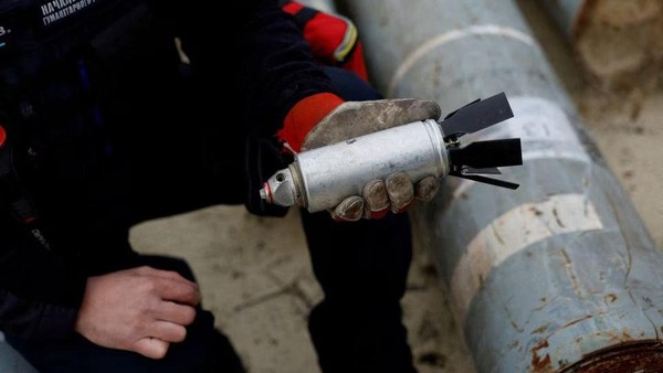 Ukrainian military serviceman Igor Ovcharruck holds a defused cluster bomb from an MSLR missile, among a display of pieces of rockets used by Russian army, that a Ukrainian munitions expert said did not explode on impact, in the region of Kharkiv, Ukraine, October 21, 2022. REUTERS/Clodagh Kilcoyne/File Photo