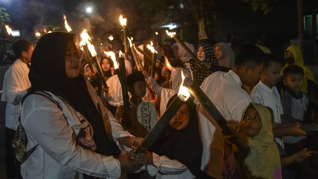 Warga menyalakan obor saat mengikuti pawai menyambut Tahun Baru Islam di Kabupaten Ciamis, Jawa Barat, Selasa (18/7/2023). Pawai obor tersebut untuk menyambut Tahun Baru Islam 1 Muharram 1445 Hijriah. ANTARA FOTO/Adeng Bustomi/foc.