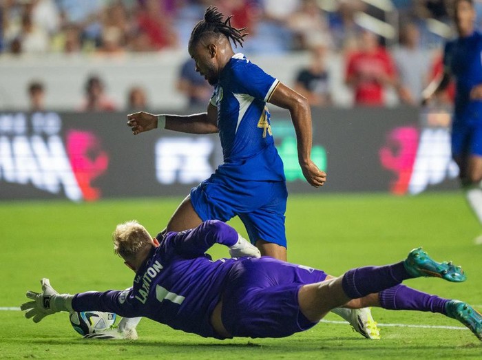 CHAPEL HILL, NORTH CAROLINA - JULY 19: Robert Lainton #1 of Wrexham AFC dives for the ball against Christopher Nkunku #45 of Chelsea FC during a pre-season friendly match at Kenan Stadium on July 19, 2023 in Chapel Hill, North Carolina.   Jacob Kupferman/Getty Images/AFP (Photo by Jacob Kupferman / GETTY IMAGES NORTH AMERICA / Getty Images via AFP)