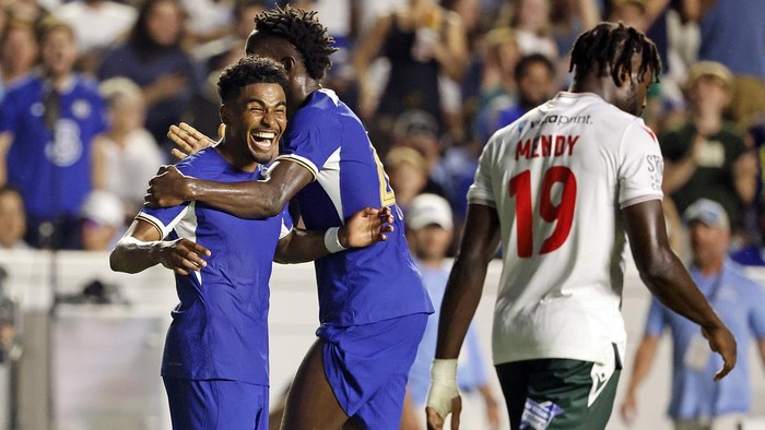 Chelseas Ian Maatson, left, celebrates a goal with Nicolas Jackson, center, while Wrexhams Jacob Mendy (19) walks past during the first half of a club friendly soccer match Wednesday, July 19, 2023, in Chapel Hill, N.C. (AP Photo/Karl B DeBlaker)