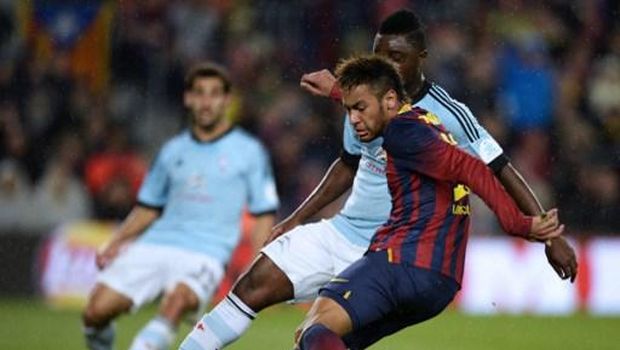 Barcelona's Brazilian forward Neymar da Silva Santos Junior (R) scores past Celta's Gabonese midfielder Levy Madinda during the Spanish league football match FC Barcelona vs RC Celta de Vigo at the Camp Nou stadium in Barcelona on March 26, 2014. AFP PHOTO / LLUIS GENE (Photo by LLUIS GENE / AFP)